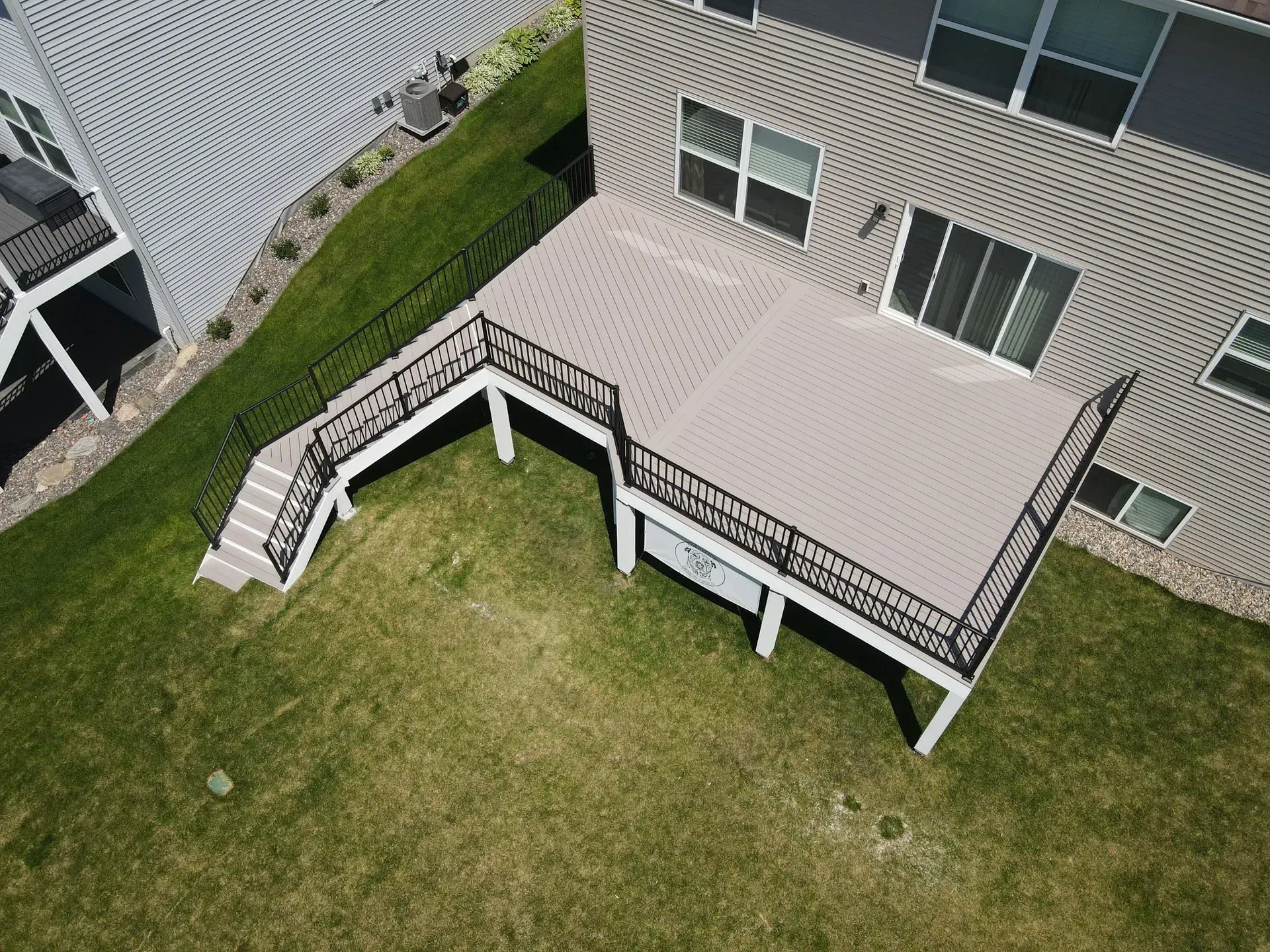 A wooden deck is being built in the dirt in front of a house.