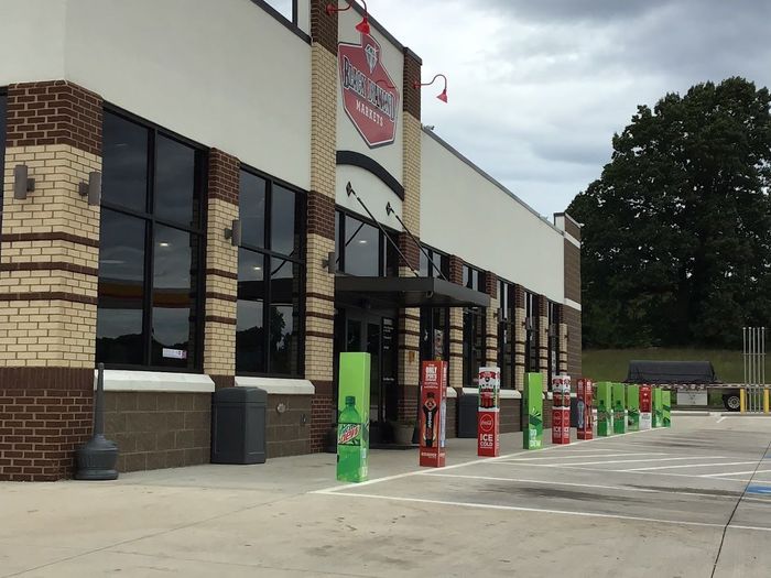 A store with a lot of windows and a sign that says ' coca cola ' on it