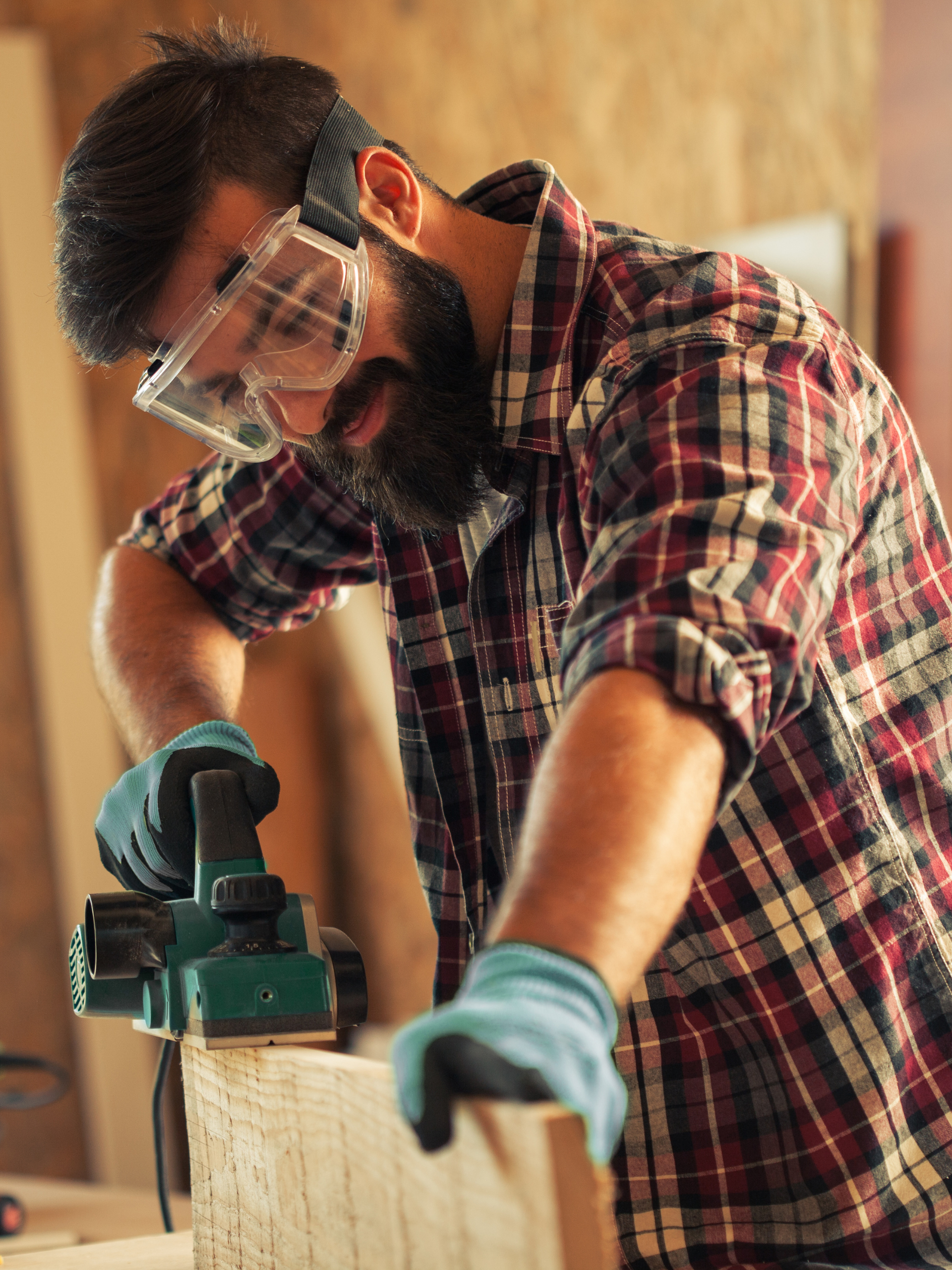 Carpenter using a saw to cut a pice of wood