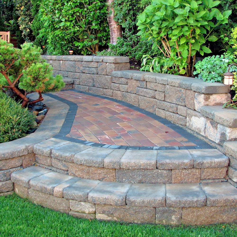 A stone wall with a brick walkway leading to it