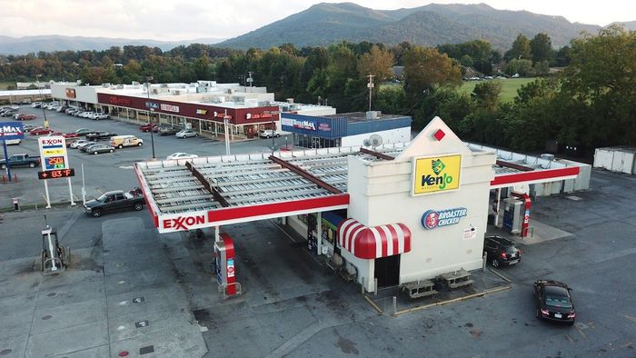 An aerial view of a gas station with mountains in the background.