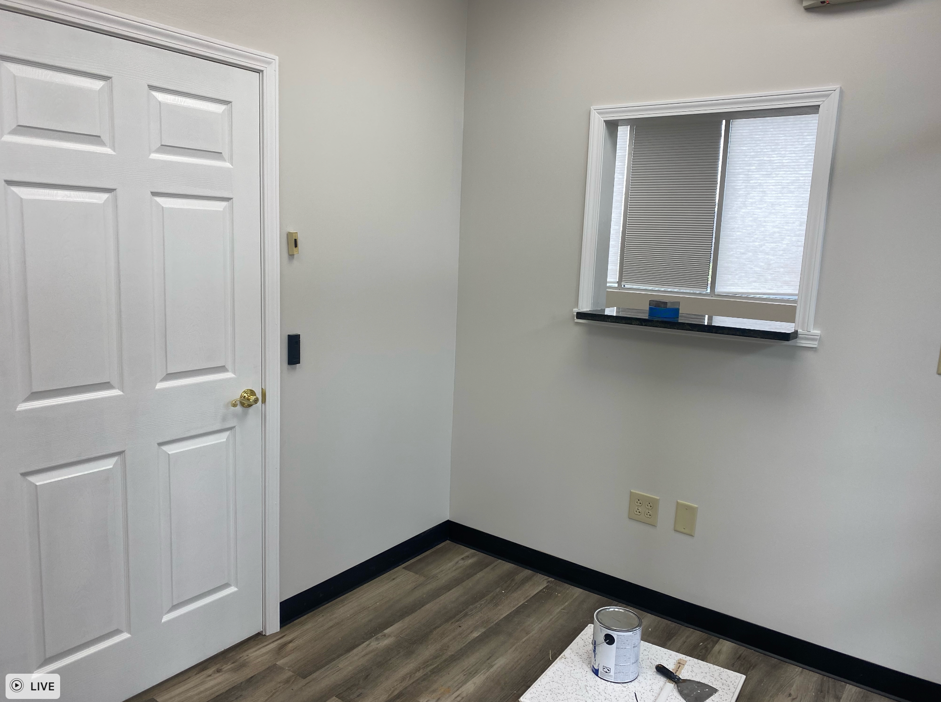 A room with a white door and a window remodeled by Hampton Construction & Development.