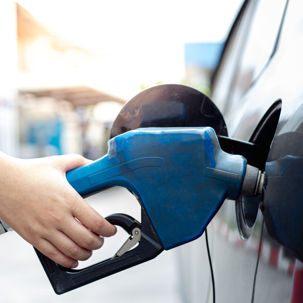 A person is pumping gas into a car at a gas station with petroleum provided by a Hampton Construction & Development installed petroleum tank