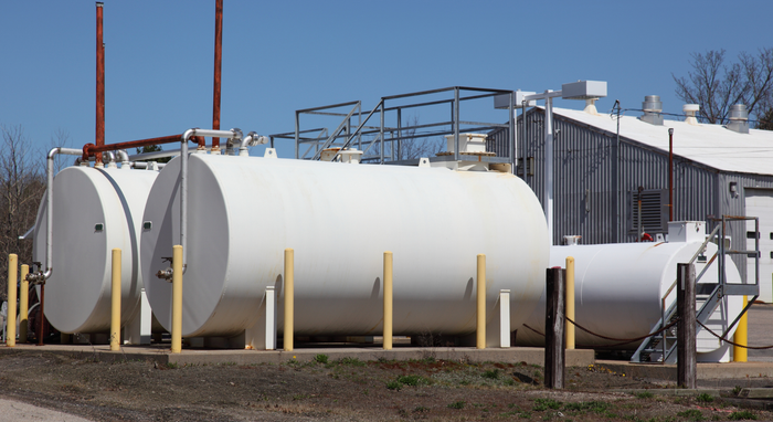 A row of white tanks are lined up in front of a building