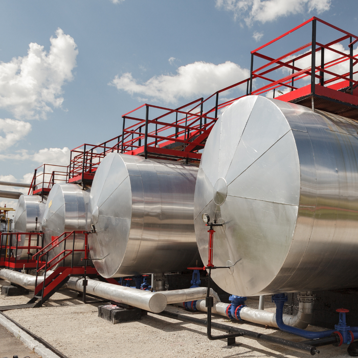A row of large metal tanks with stairs leading up to them