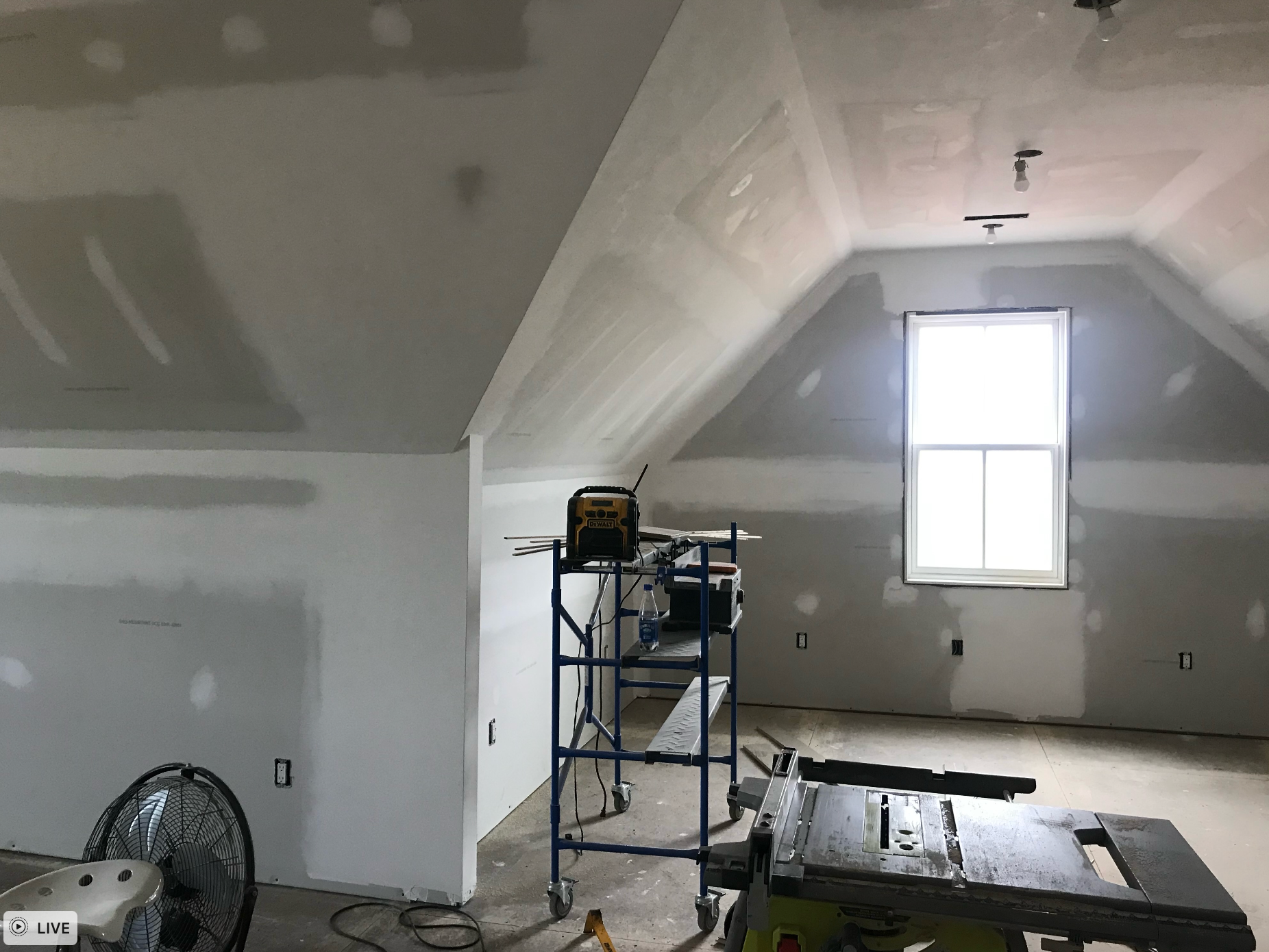 A room with a scaffolding and a table saw in it.