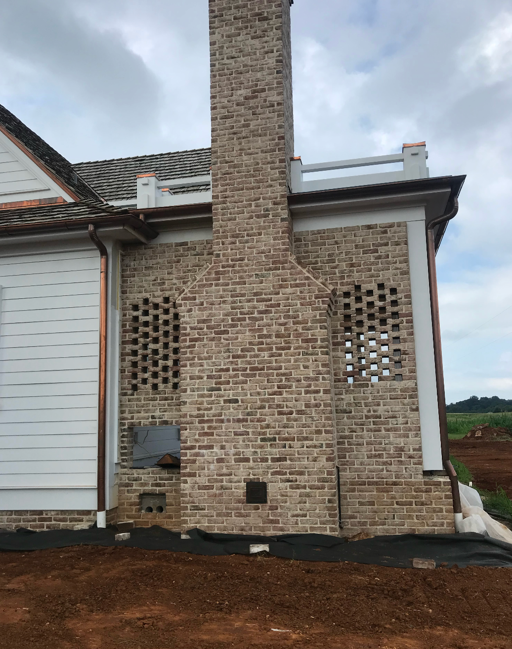 A large brick chimney on the side of a house