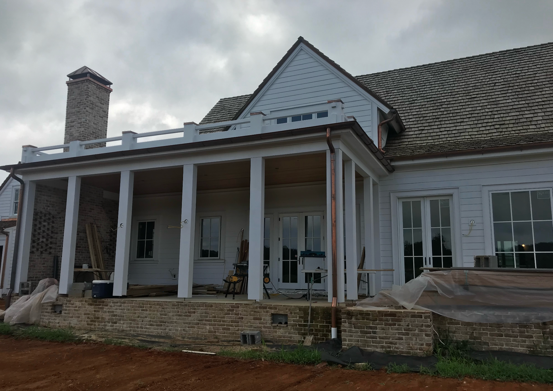 A large white house with a porch and a chimney