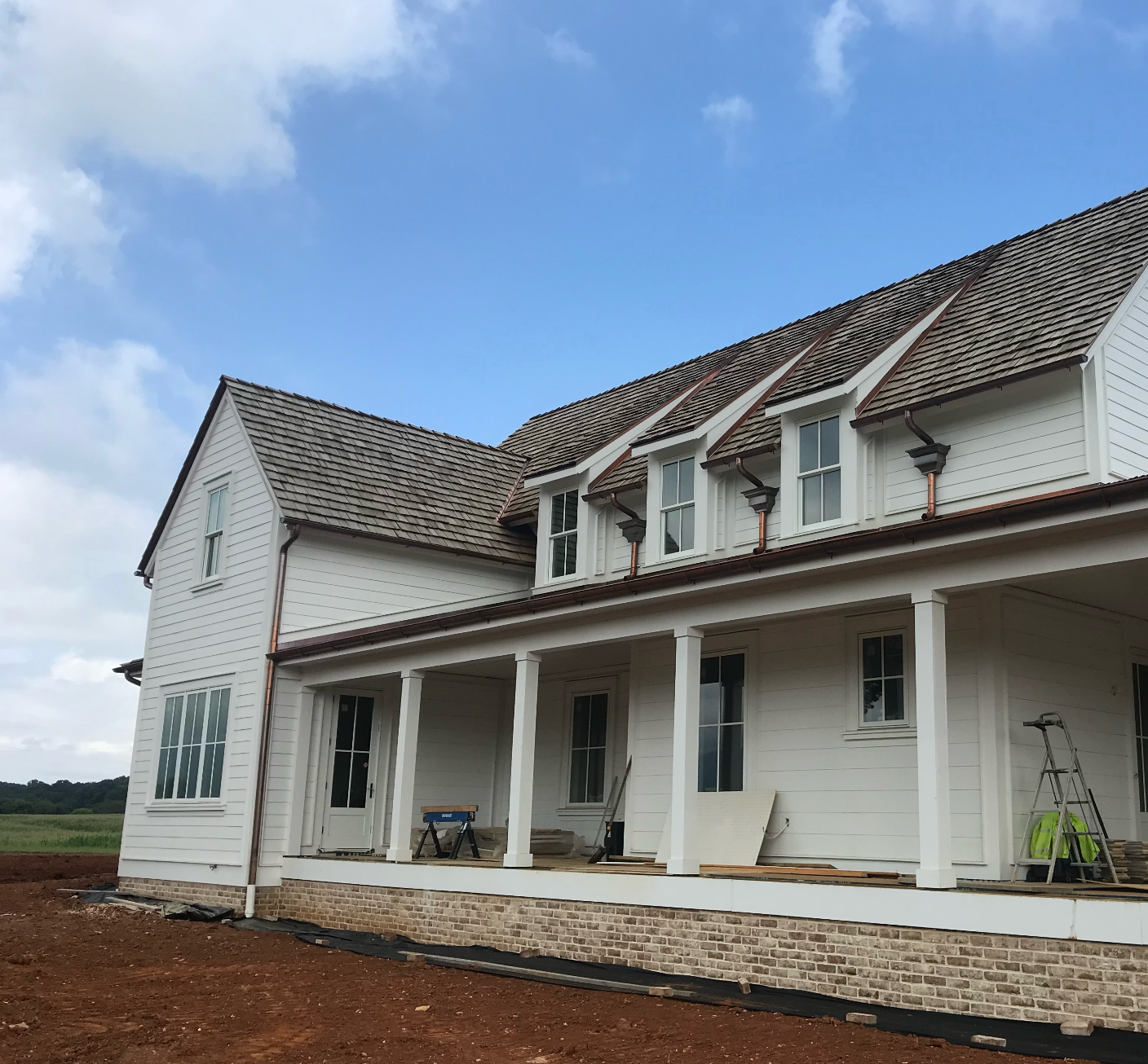A large white house with a porch and a roof