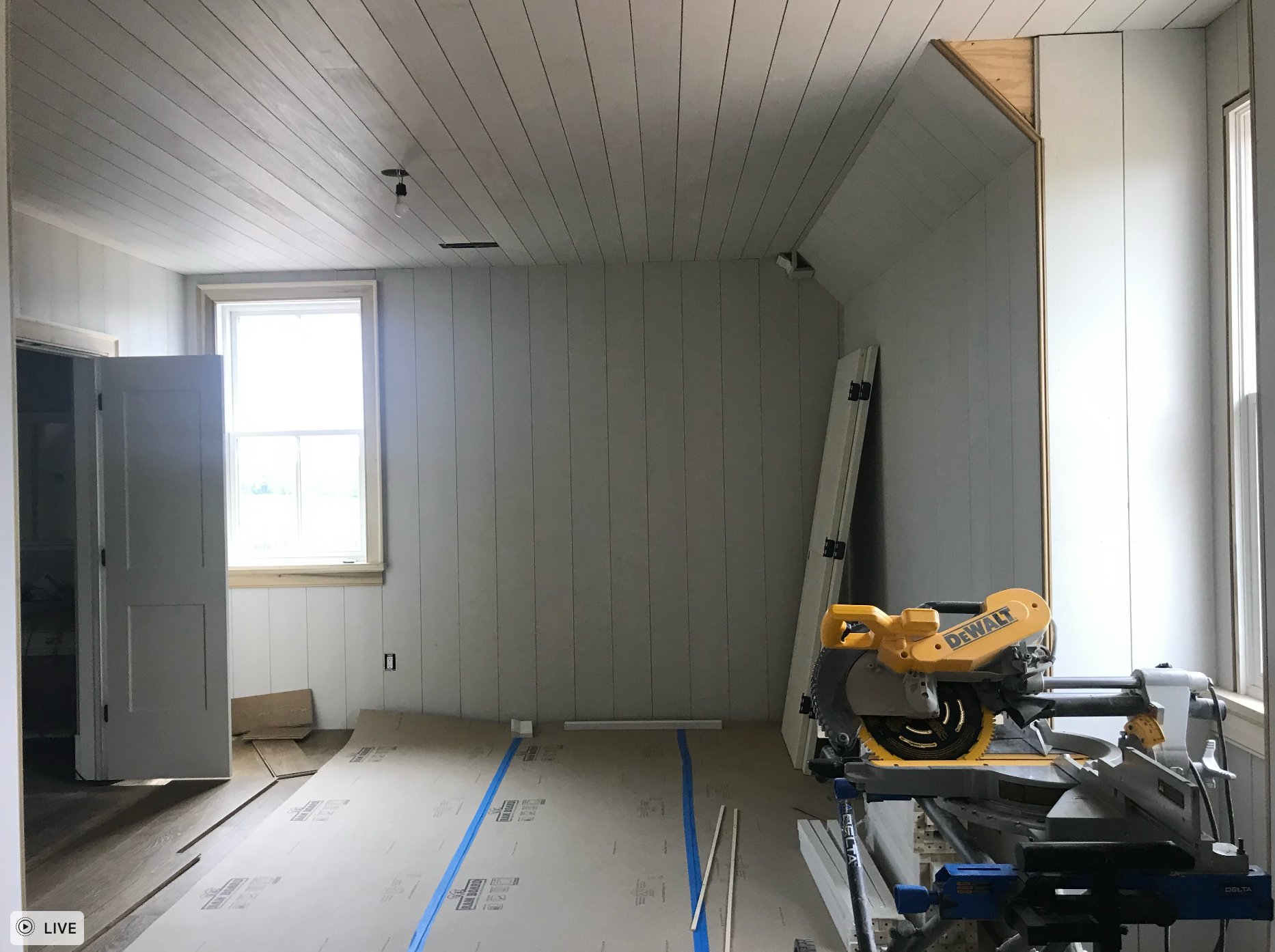 A yellow dewalt saw is sitting in a room