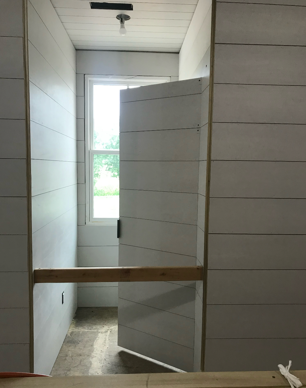 A white door is open in a room with a window