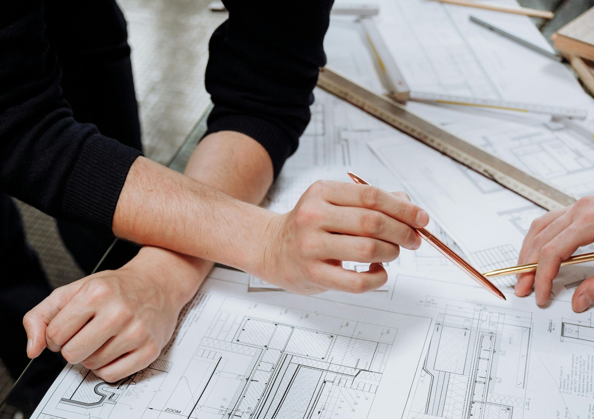 A group of people are sitting around a table looking at a blueprint.
