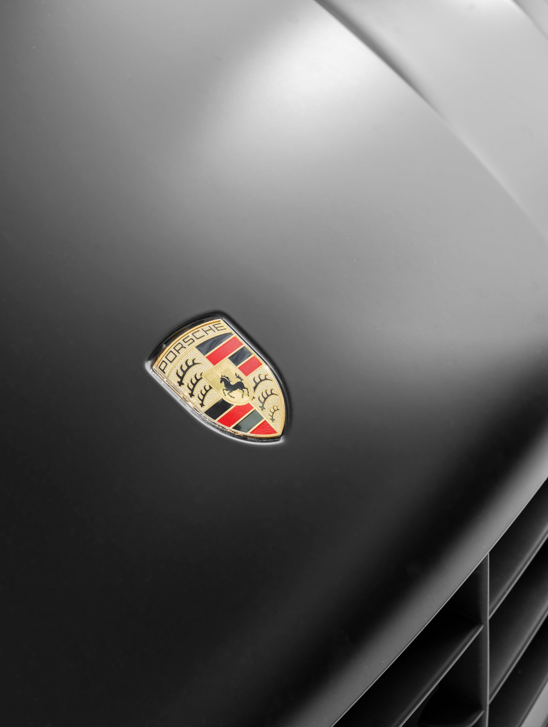 A close up of a porsche emblem on a black car