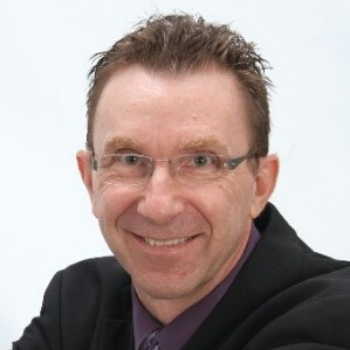 Smiling man in glasses and dark suit on a white background