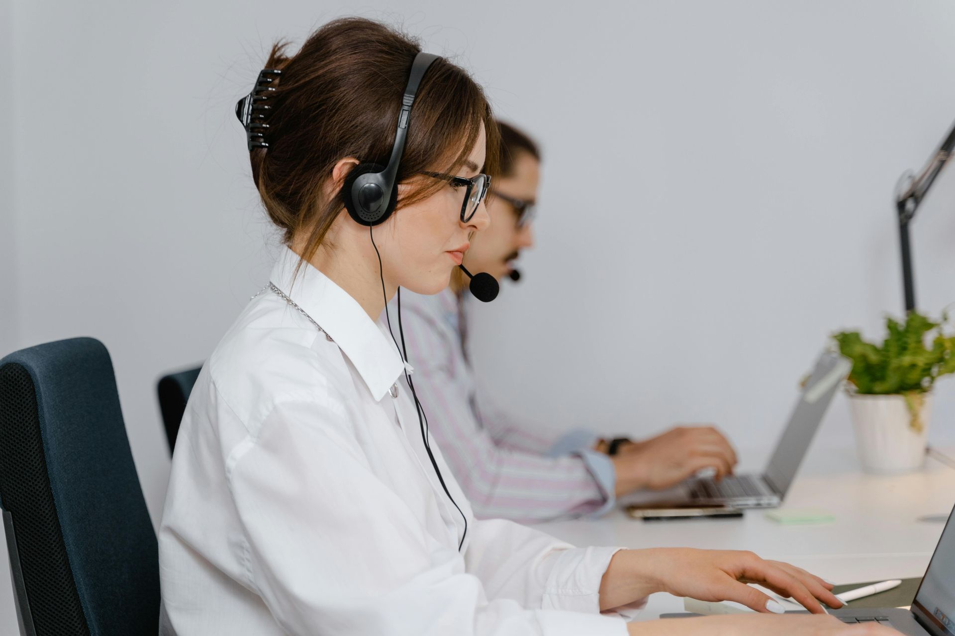 People wearing headsets working at computers in an office call center