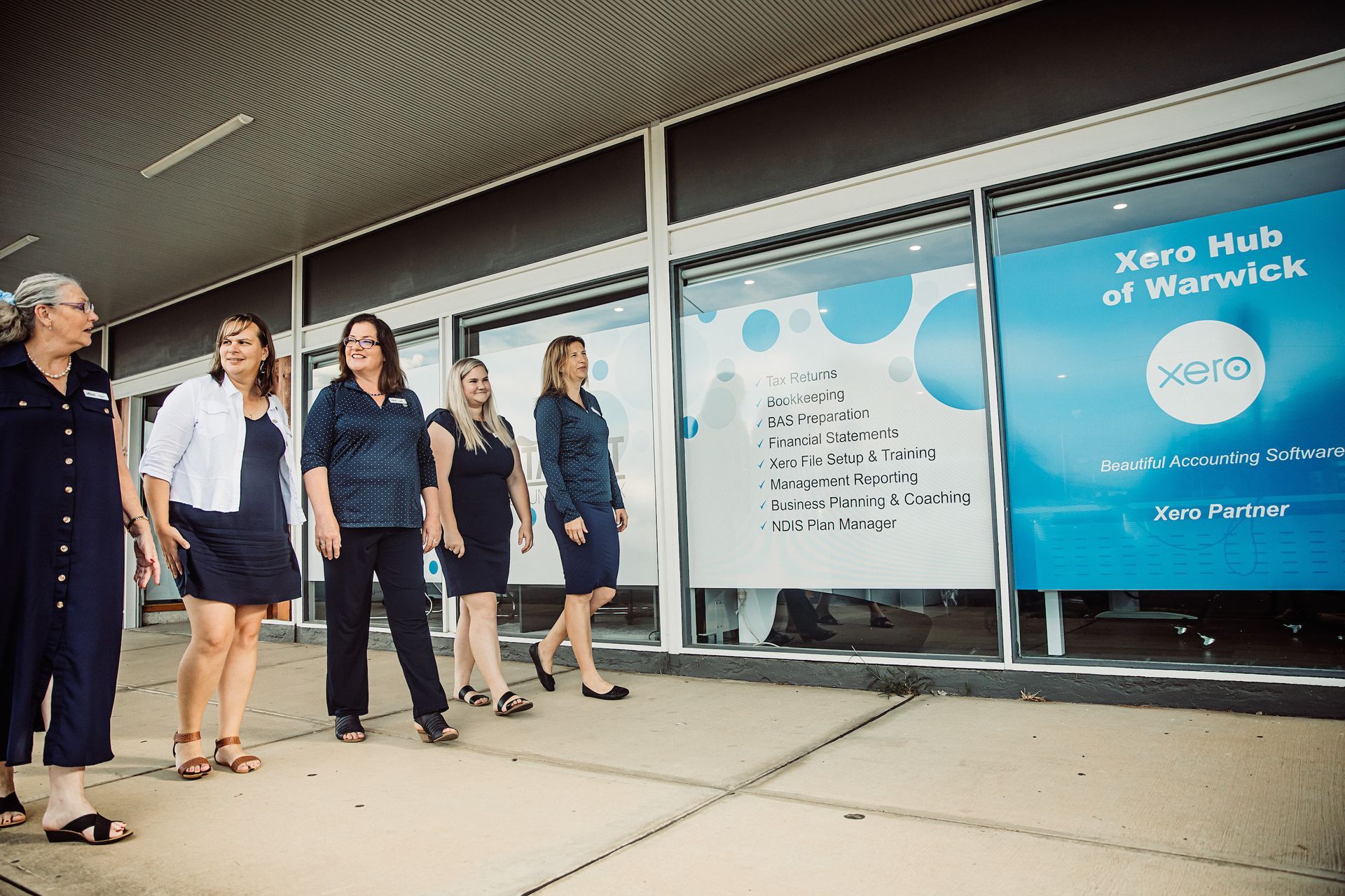 A Group of Women Are Standing in Front of A Building — Catalyst Accounting & Tax in Millaa Millaa, QLD