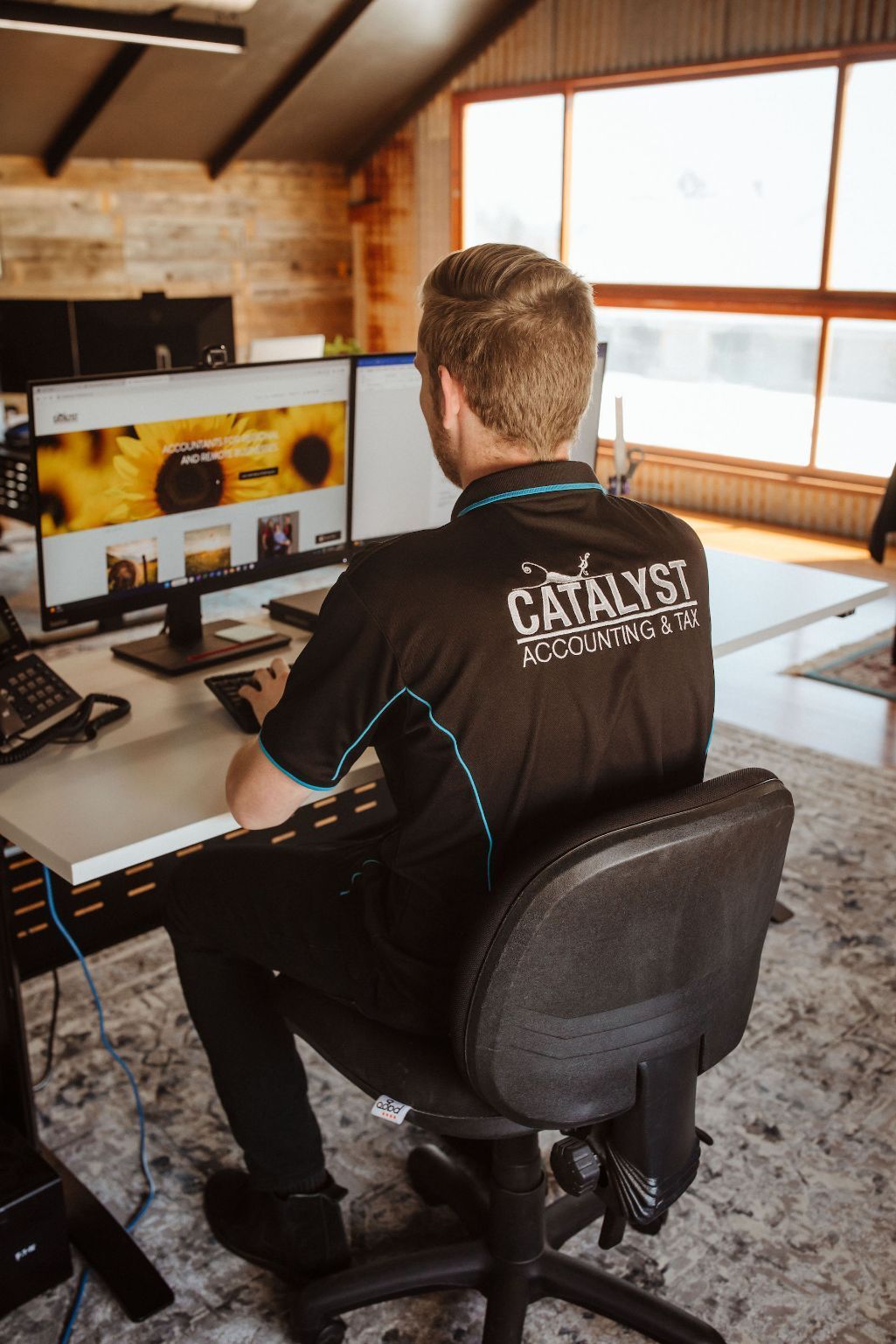 A Man Is Sitting at A Desk in Front of A Computer — Catalyst Accounting & Tax in Killarney, QLD