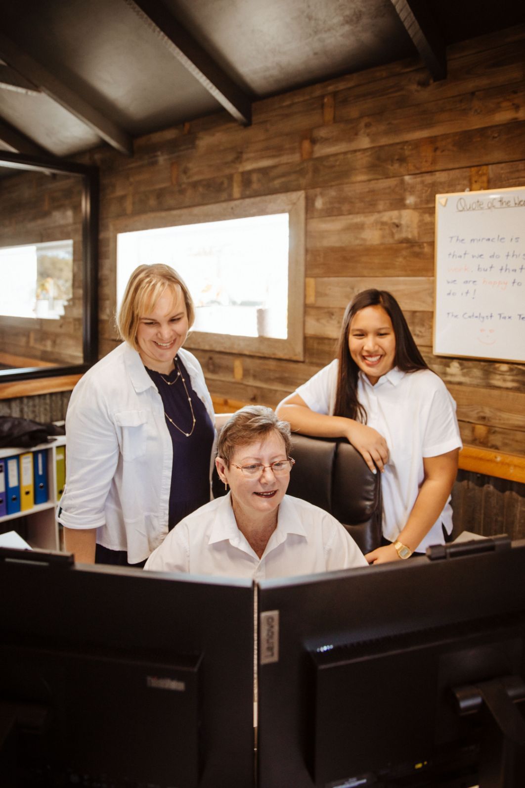 Three Women Are Standing Around a Computer Monitor in An Office — Catalyst Accounting & Tax in Warwick, QLD