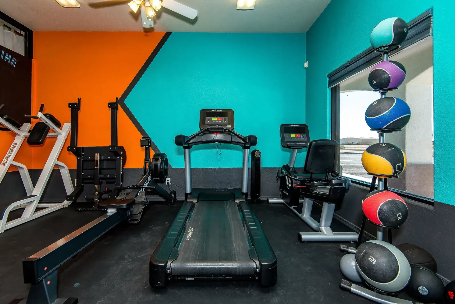 Colorful Form and Function Fitness gym in Fort Mohave, AZ with treadmills, weight machines, and medicine balls on a rack