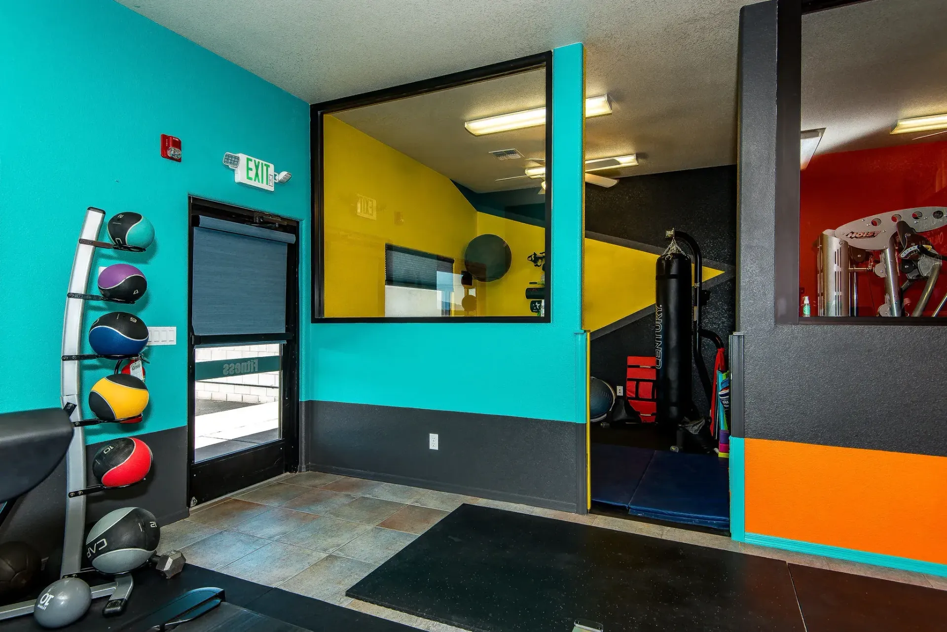 Colorful Form and Function Fitness gym in Fort Mohave, AZ, interior with medicine balls, mirrors, and exercise mats near a doorway