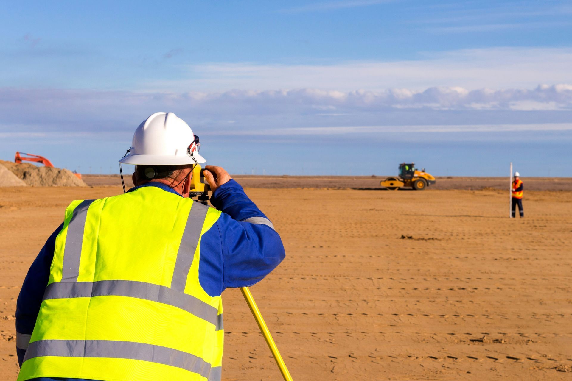 Surveyor taking height and level measurements on a construction site