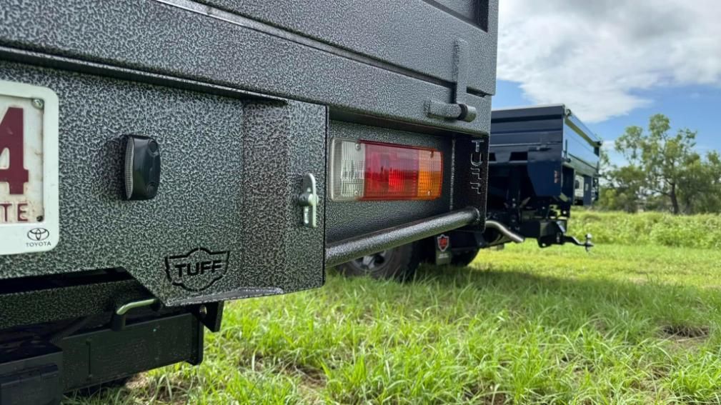 A Truck With a Trailer Attached to It is Parked in a Grassy Field — Emerald 4x4 in Emerald, QLD
