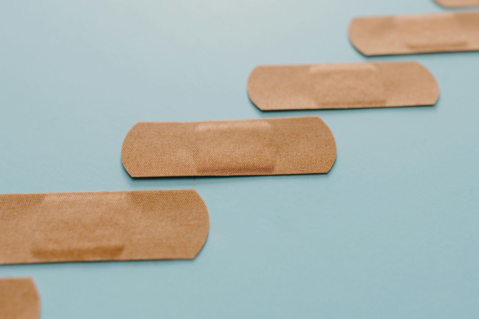 Band-aids in a row on a blue surface.