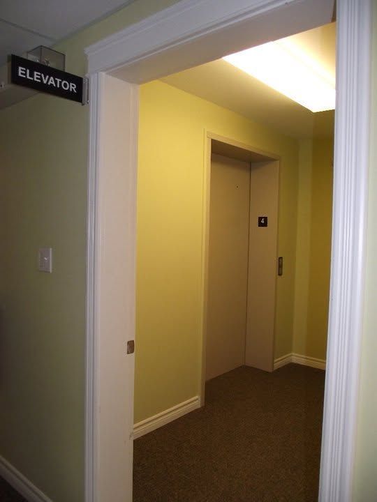 Hallway leading to an elevator, with a black 