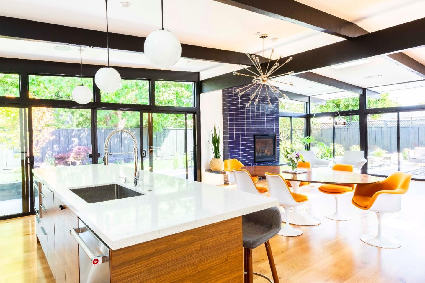 A kitchen with a large island , sink , table and chairs.