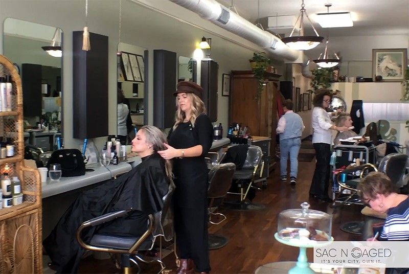 A woman is getting her hair cut in a salon.