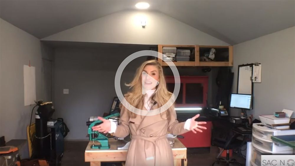 A woman in a trench coat is standing in a garage.