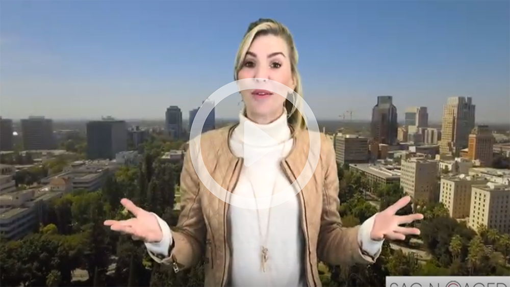 A woman is standing in front of a city with her arms outstretched.