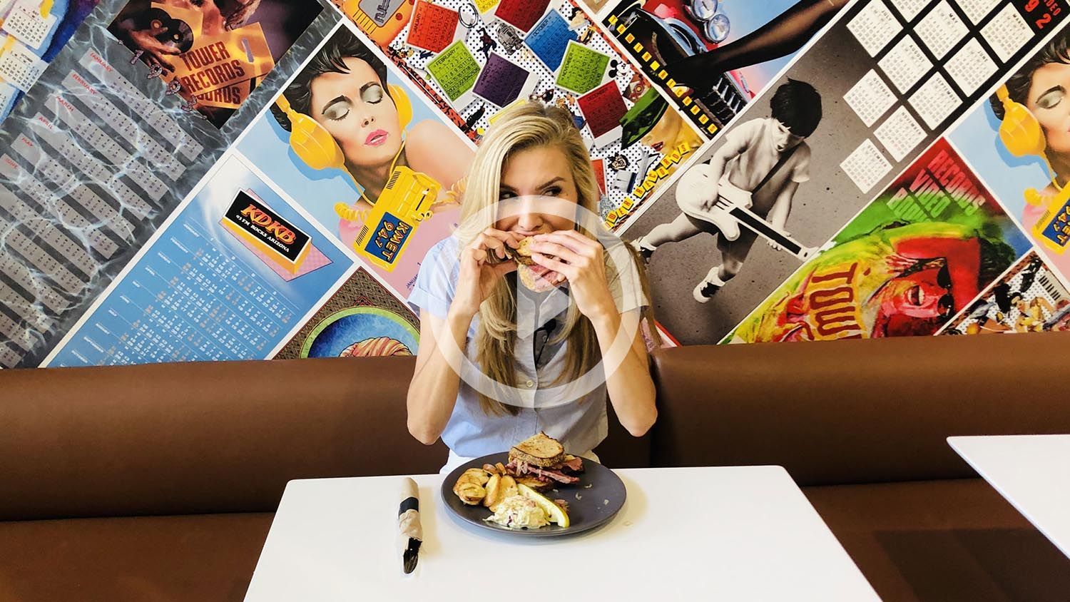 A woman is sitting at a table with a plate of food.