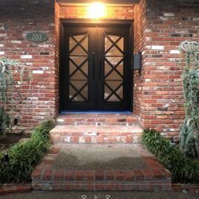 The front door of a brick house with the number 207 on it