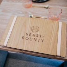A wooden menu is sitting on top of a wooden table.