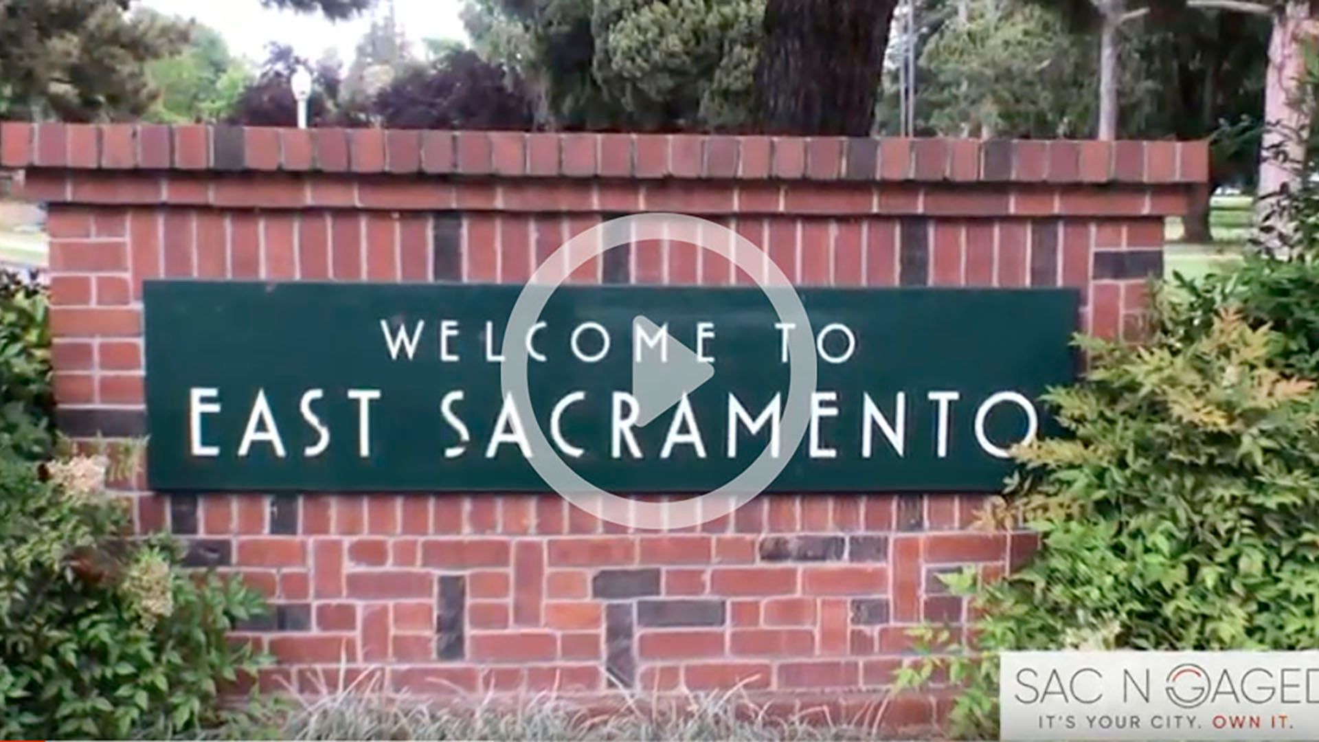 A welcome to east sacramento sign on a brick wall