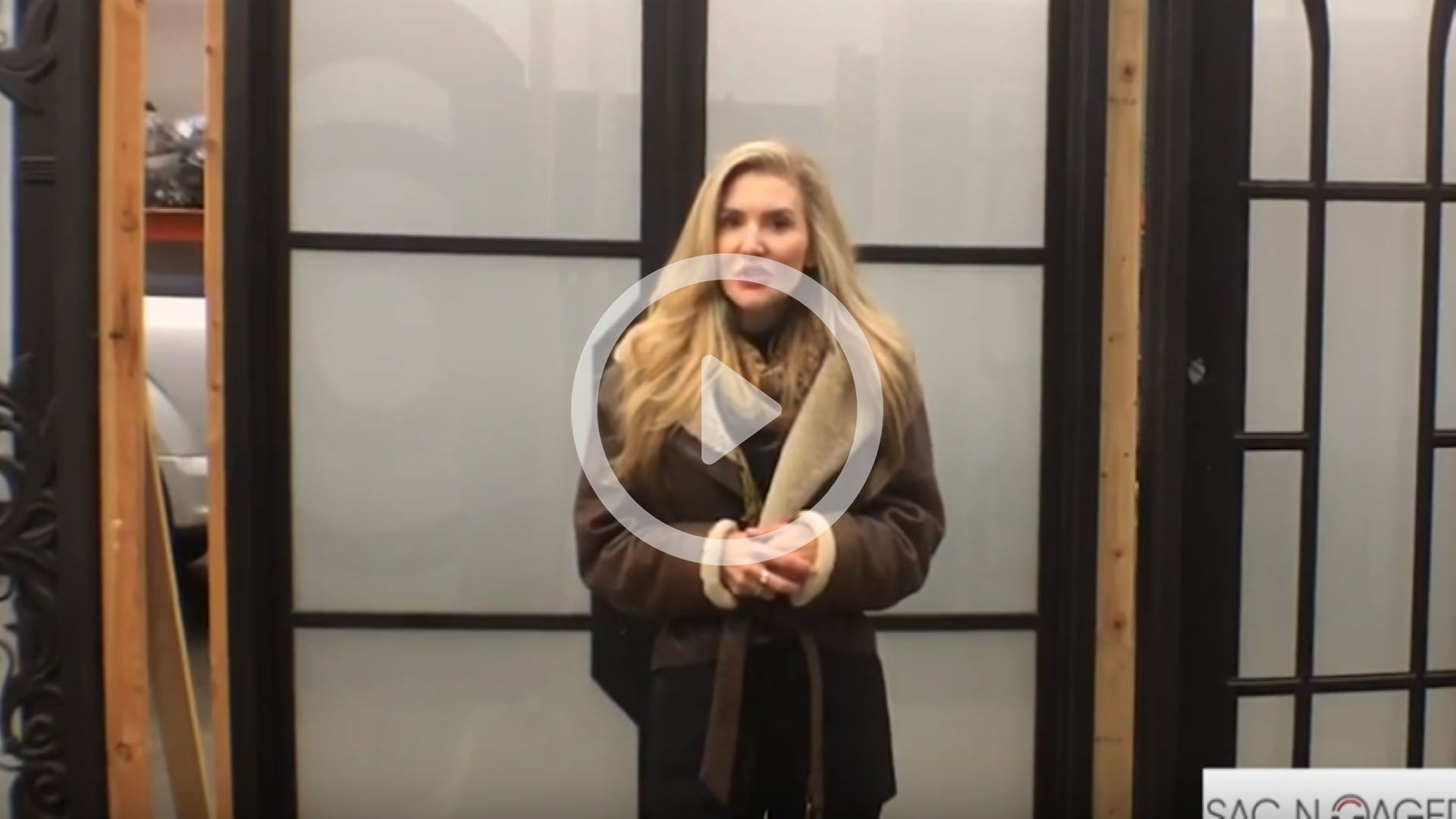 A woman is standing in front of a door in a video.
