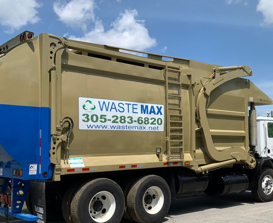 A waste max garbage truck is parked on the side of the road