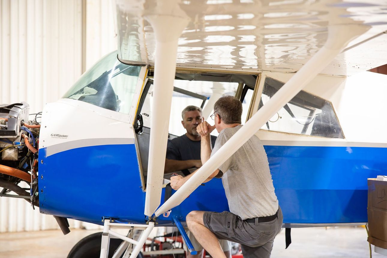Dennis, founder of Omega Aircraft Services, standing beside an aircraft