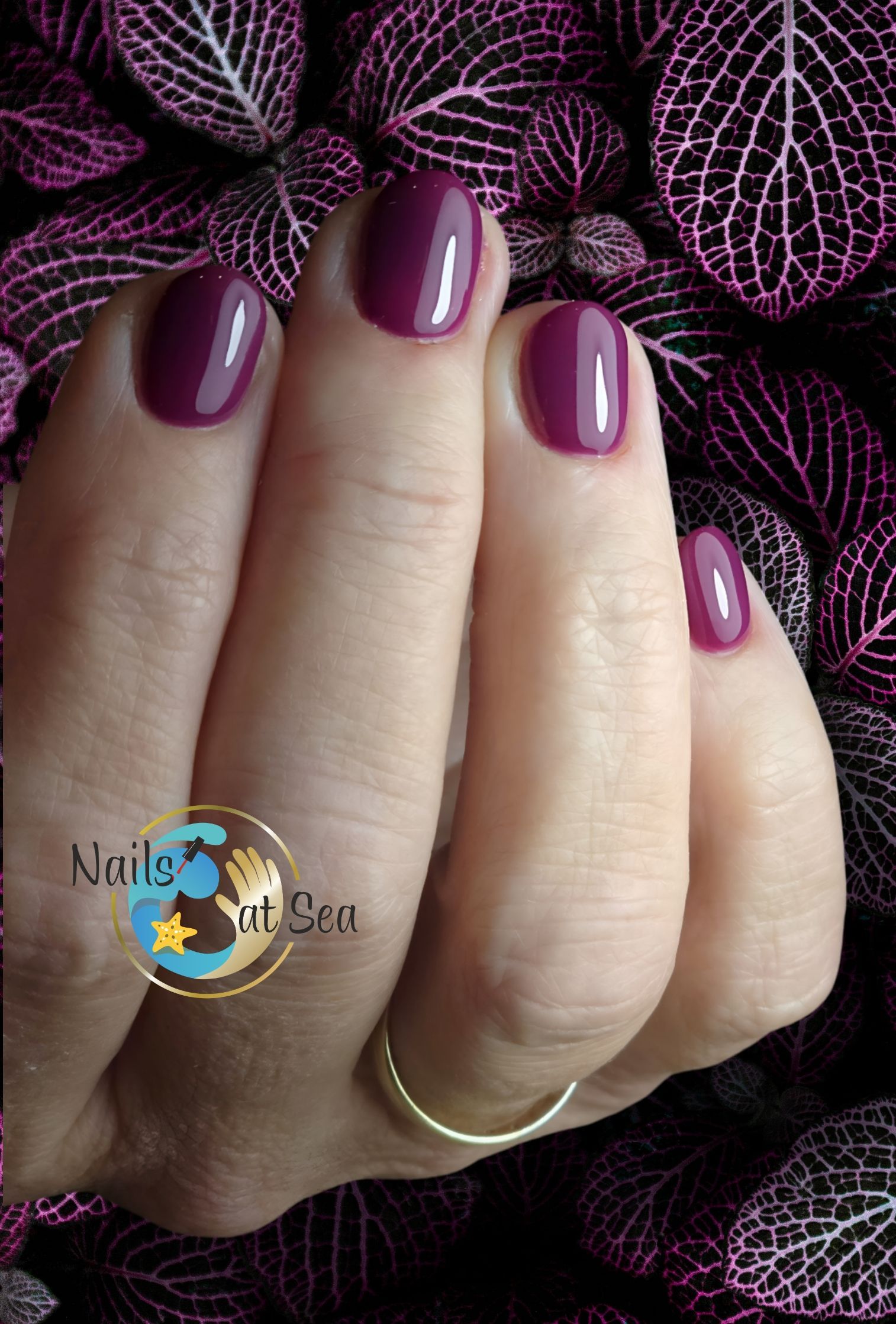 Een close-up van de hand van een vrouw met paarse nagels