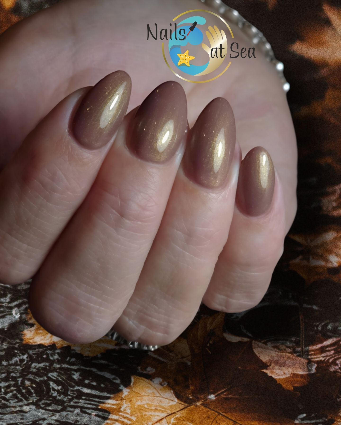 Een close-up van de nagels van een vrouw met de woorden nagels uit zee op de bodem