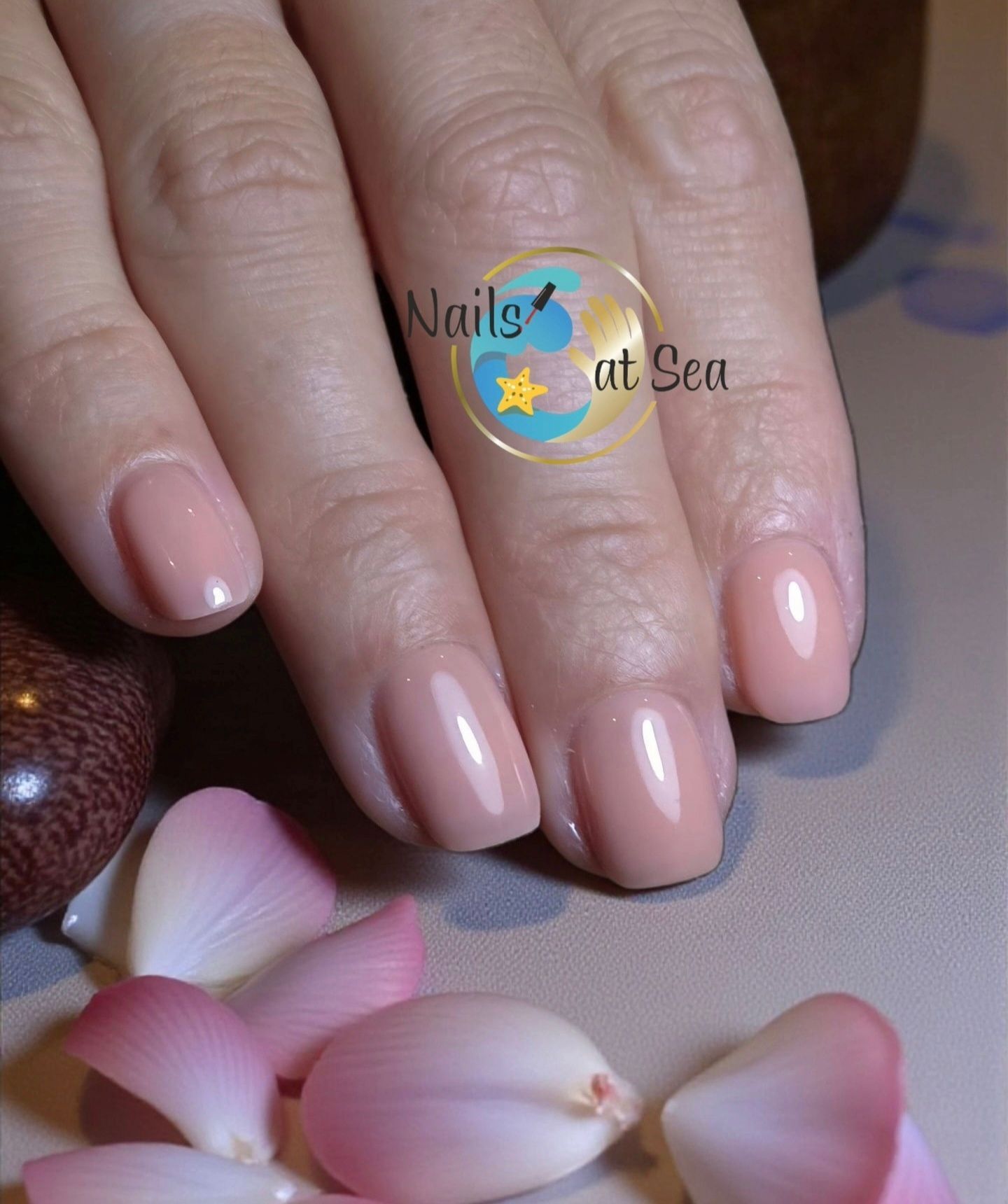Een close-up van de hand van een vrouw met rode nagels en een logo voor nagels op zee
