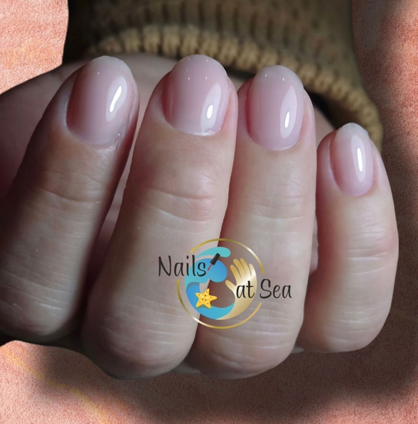 Een close-up van de nagels van een vrouw met de woorden nagels op zee op de bodem