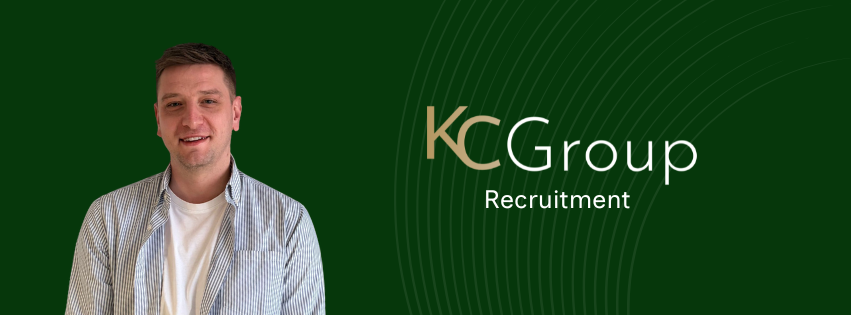 Man standing beside KC Group Recruitment logo on a dark green background