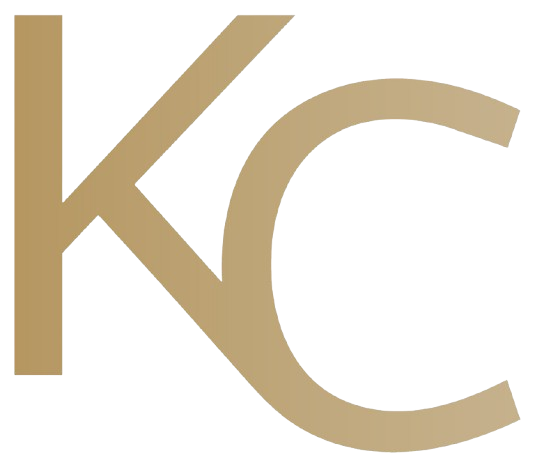 A gold kc logo on a white background