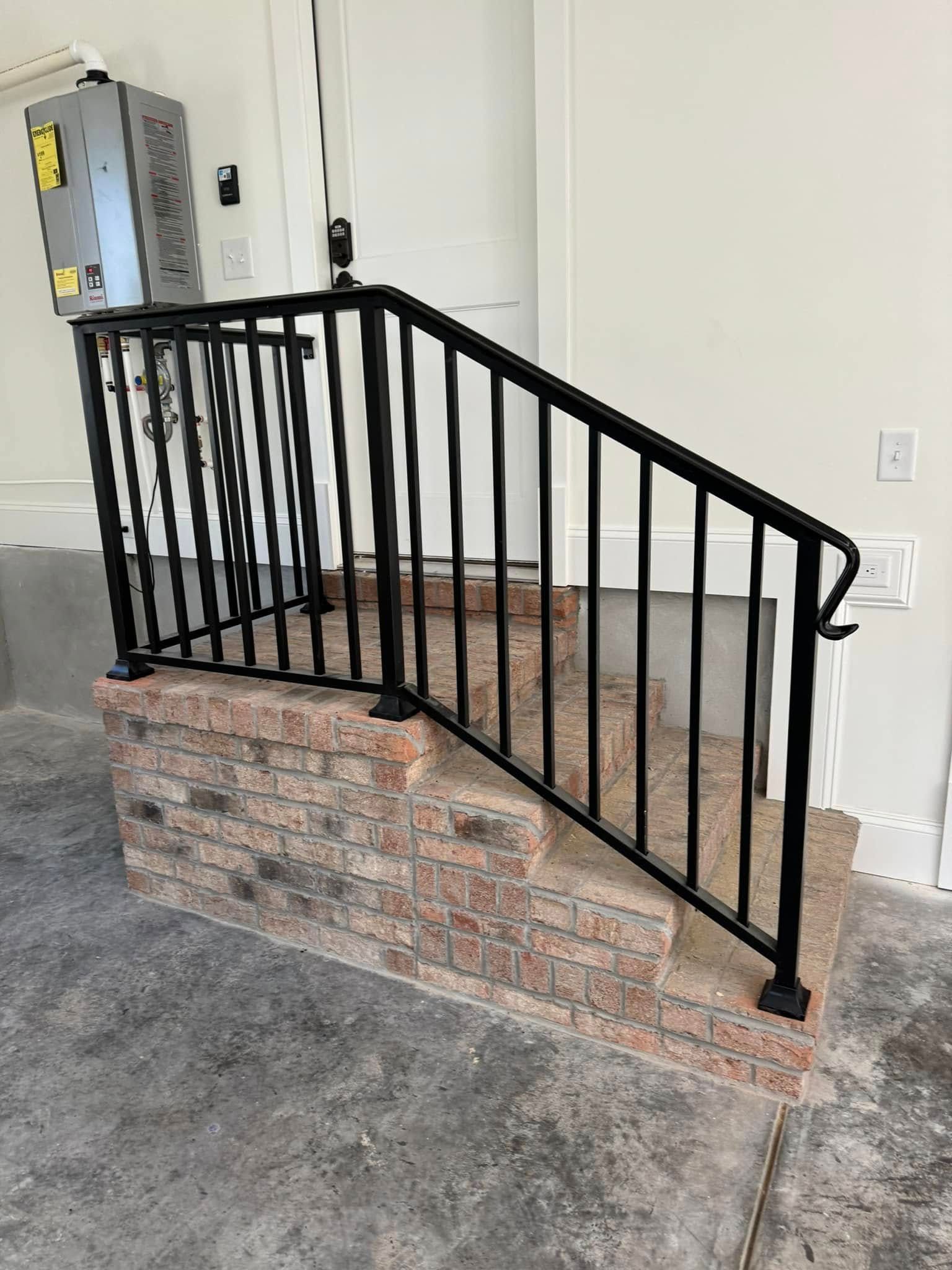 Black metal stair railing beside brick steps in a carpeted interior