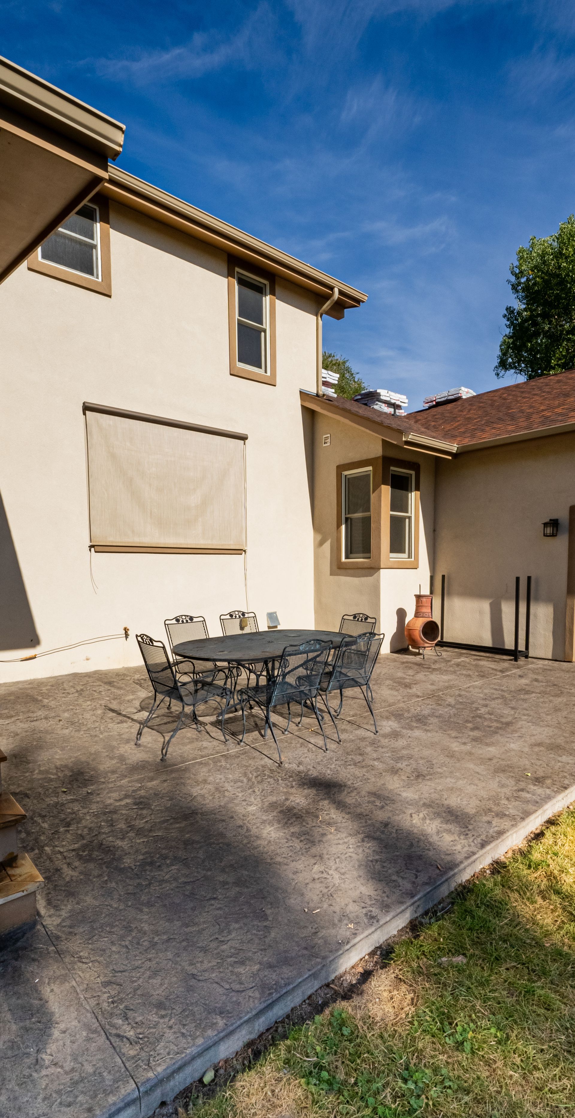 An artist 's impression of a backyard with a patio and furniture.