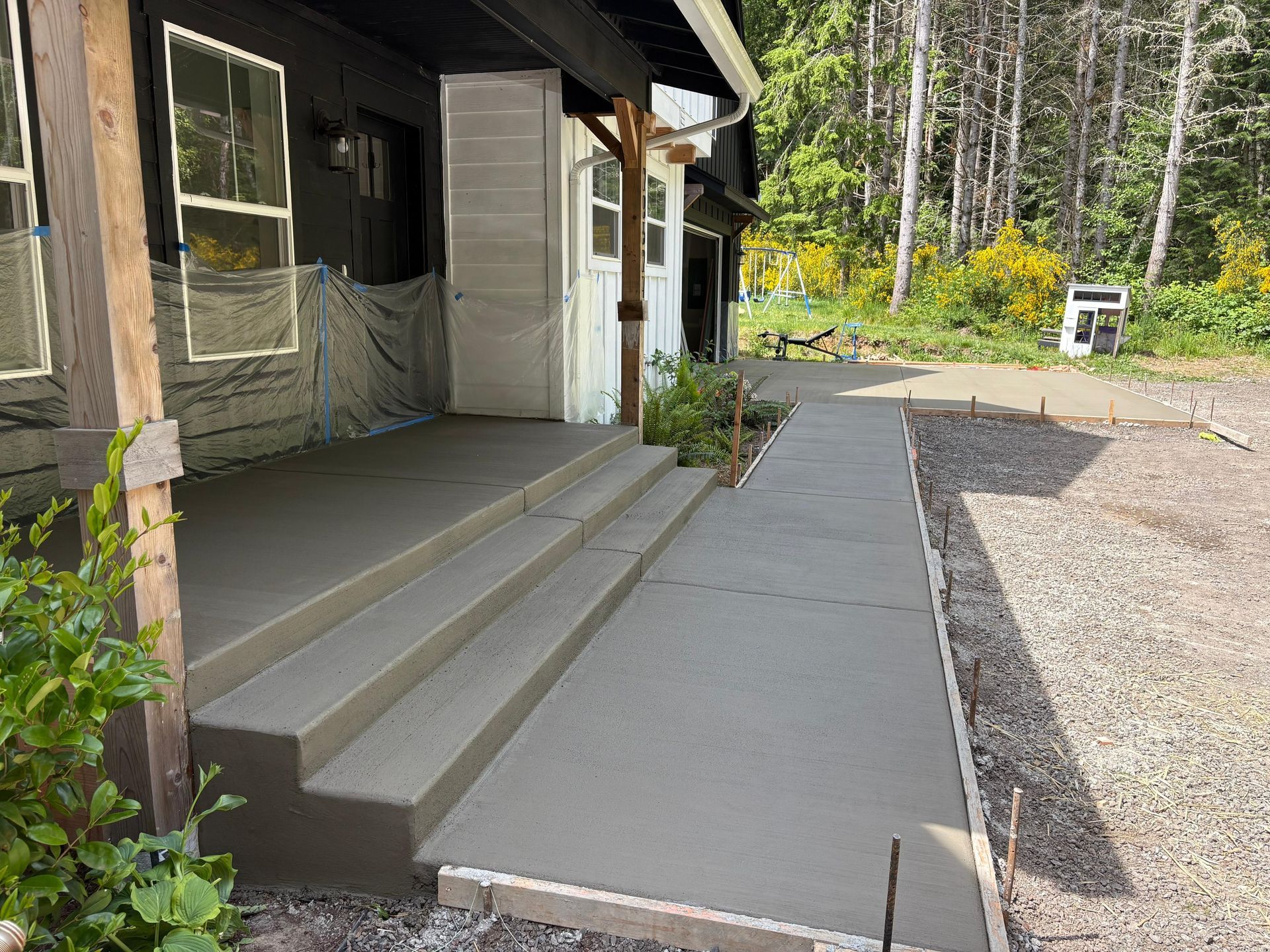 A concrete walkway leading to a row of houses with a white fence.