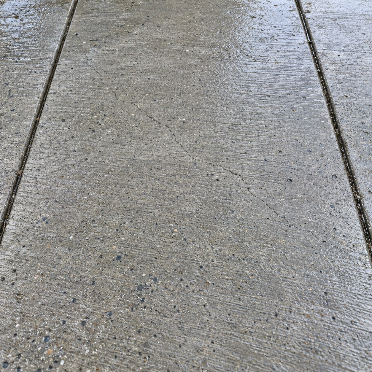 Shrinkage crack in a concrete slab next to a control joint