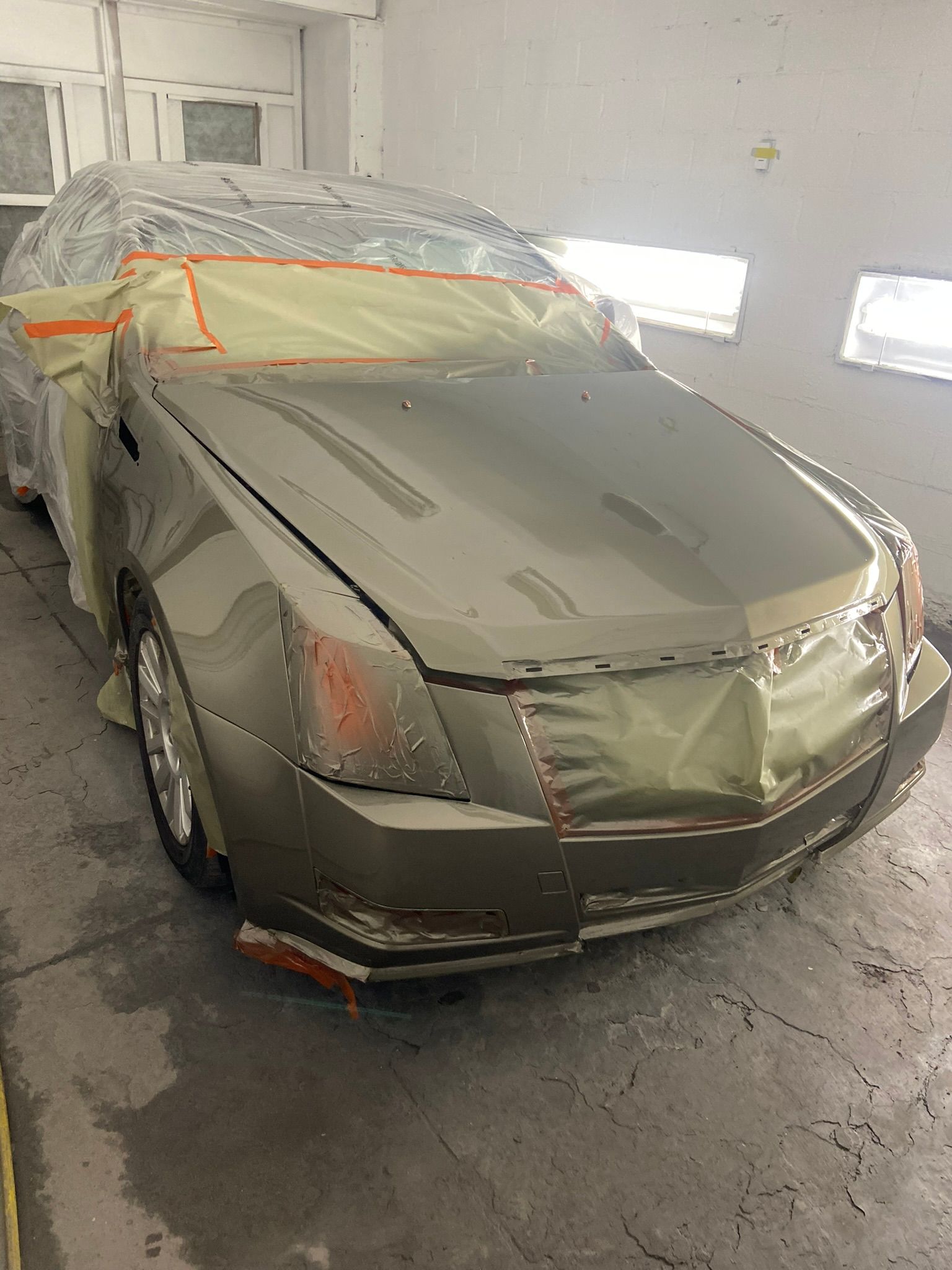 A Car Is Covered in Plastic Wrap in A Garage — Chicago, IL — Ecuamex Autobody Inc.